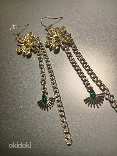 Statement flower earrings with green crystals and chains.